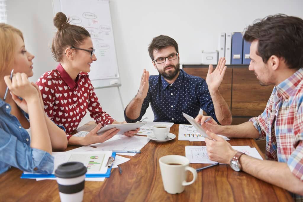 Un groupe de personnes assises autour d'une table en pleine discussion.