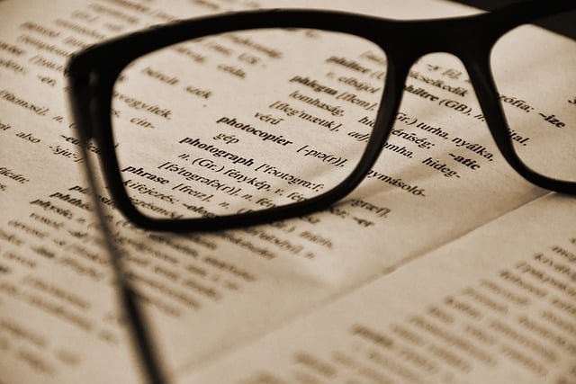 Paire de lunettes posée sur un livre ouvert, symbolisant la lecture attentive, l'expertise et la précision, idéales pour illustrer la traduction juridique assermentée sur Tradyx.