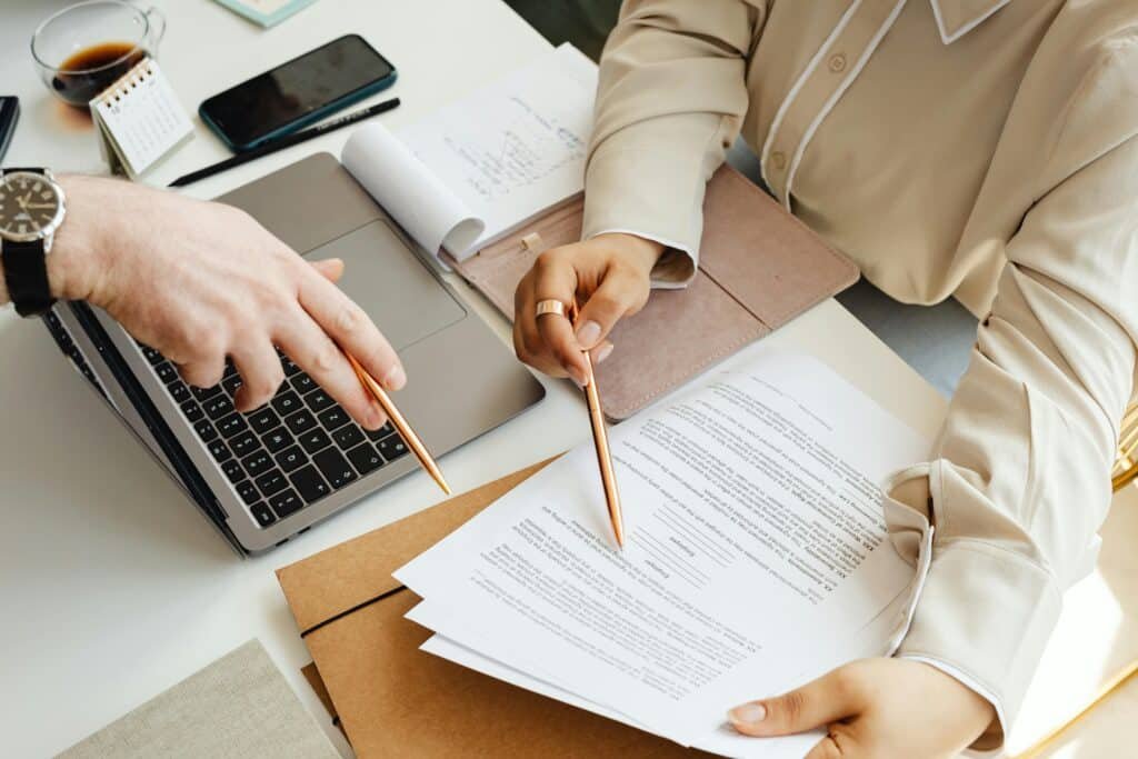 Deux personnes discutant autour d’un document, illustrant l’interprétation de liaison pour une communication fluide et précise dans un contexte juridique ou professionnel sur Tradyx.